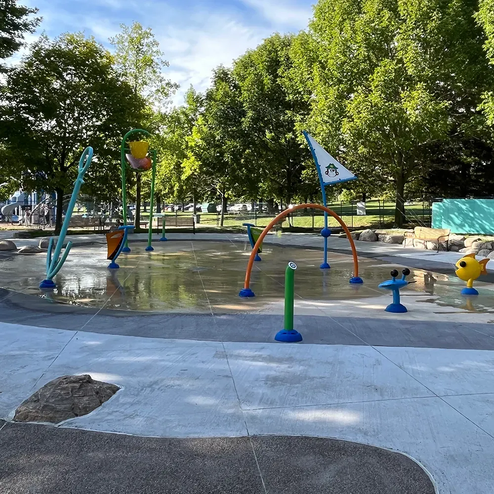 A splash pad featuring various water spraying and dumping structures.