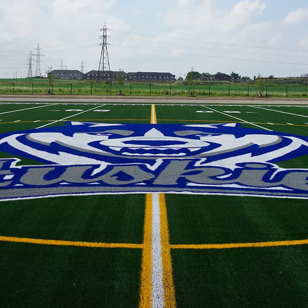 A Huskies logo on a football field is a custom turf installation by 39 Seven.