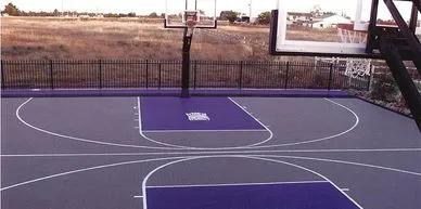An outdoor basketball court with a purple rubberized playing surface.