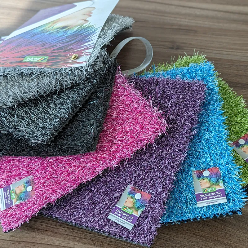 Samples of colored turf in pink, blue, purple, grey and others are displayed on a table.
